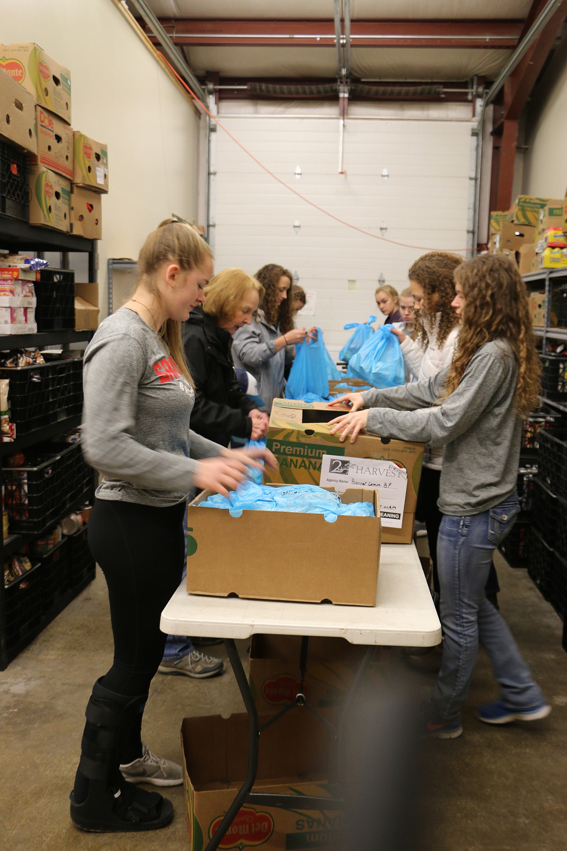 (Photo by MARY MALONE)
The Sandpoint High School girls varsity team volunteered at the Bonner Community Food Bank on Wednesday, packing up food for the Backpack program, which feeds kids from low-income families in the Lake Pend Oreille School District.