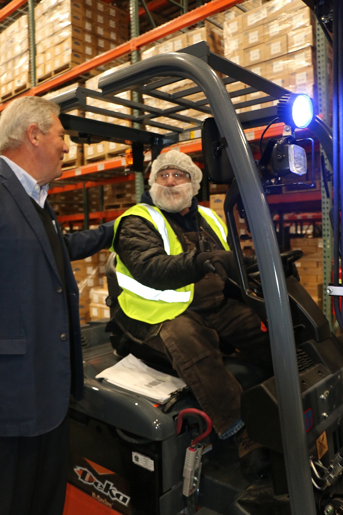 (Photo by CAROLINE LOBSINGER)LItehouse President and CEO Jim Frank, left, talks to Scooter Reichart after he drove a forklift through a ceremonial ribbon to celebrate the Ella Avenue production facility's expansion. The different take isn't unusual for the company &#151; when it kicked off the project, company officials and employees took turns whacking holes in a soon-to-be-gone wall with a sledgehammer instead of using more traditional shovels.