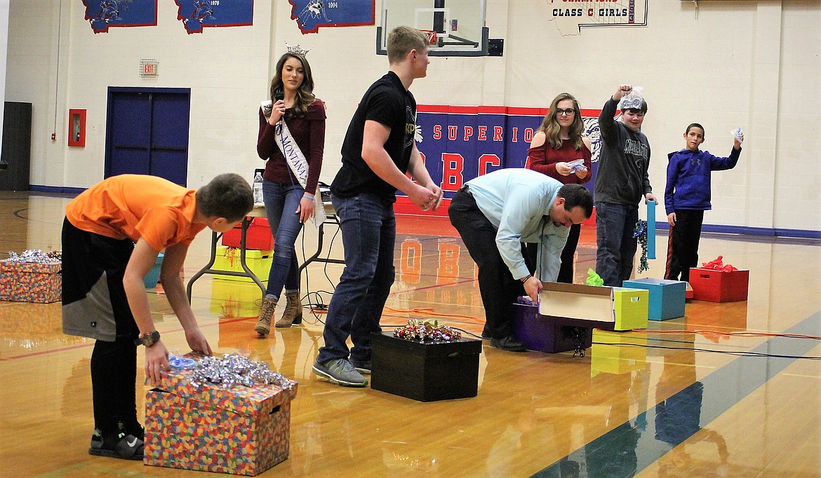 Several students at Superior High School were called up to receive a gift during Miss Montana&#146;s presentation on Wednesday. They then had the chance to either keep their gift box or give it to someone else.  Everyone had a chance to give their gift away and receive another gift in return. (Principal Chris Clairmont searches his box for a gift but came up empty.) (Kathleen Woodford/Mineral Independent)