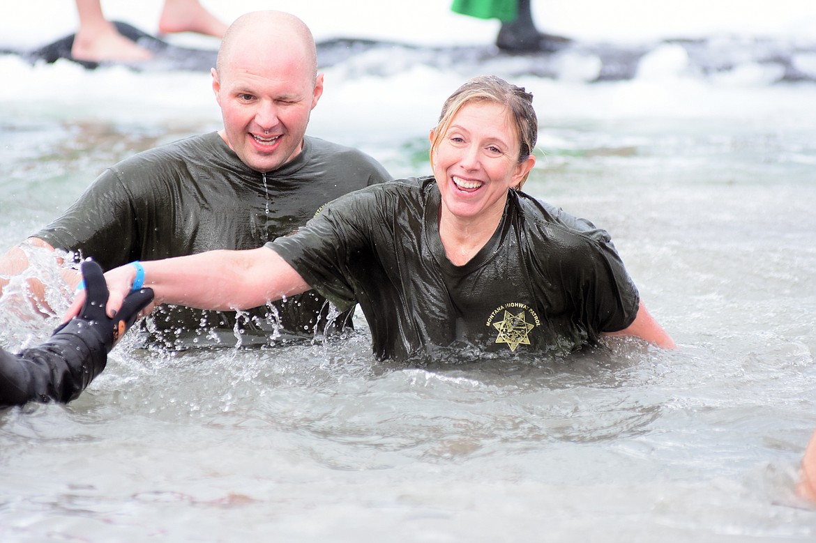 Members of the Montana Highway Patrol team emerge from the water of Whitefish Lake Saturday morning for the Whitefish Winter Carnival Penguin Plunge, which benefits Special Olympics Montana. (Heidi Desch/Whitefish Pilot)