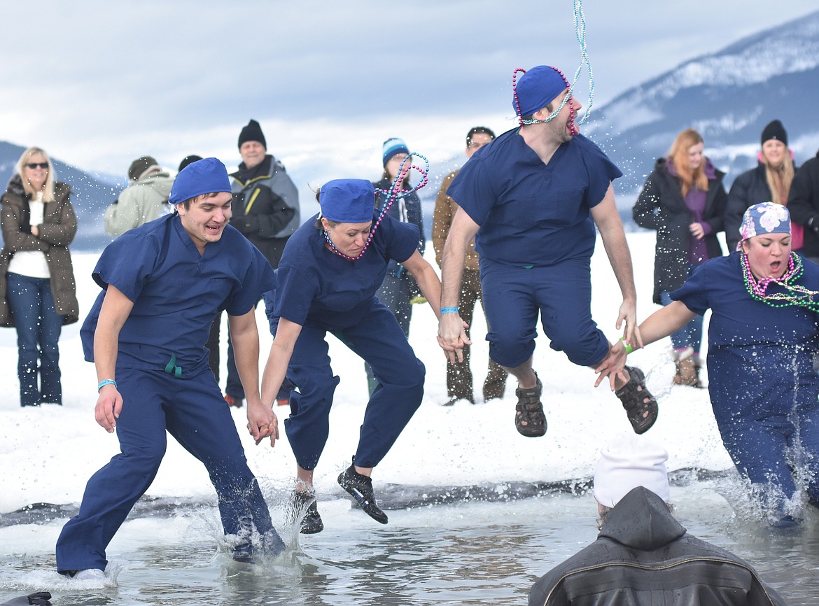 Participants jump into the icy waters of Whitefish Lake Saturday morning for the Whitefish Winter Carnival Penguin Plunge, which benefits Special Olympics Montana. (Heidi Desch/Whitefish Pilot)