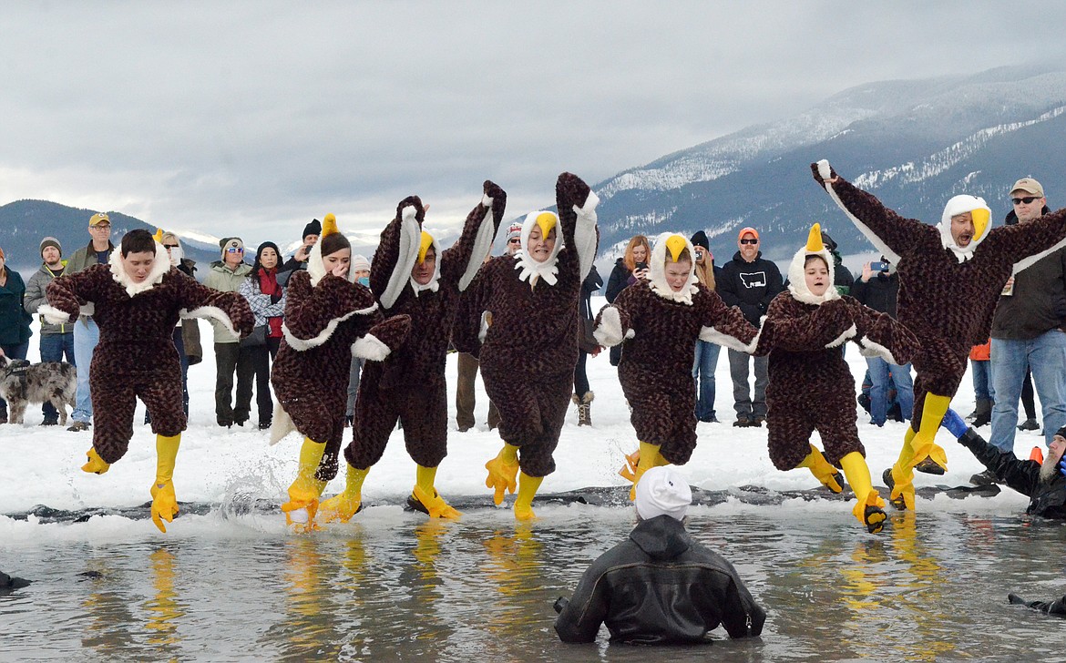 Participants jump into the icy waters of Whitefish Lake Saturday morning for the Whitefish Winter Carnival Penguin Plunge, which benefits Special Olympics Montana. (Heidi Desch/Whitefish Pilot)