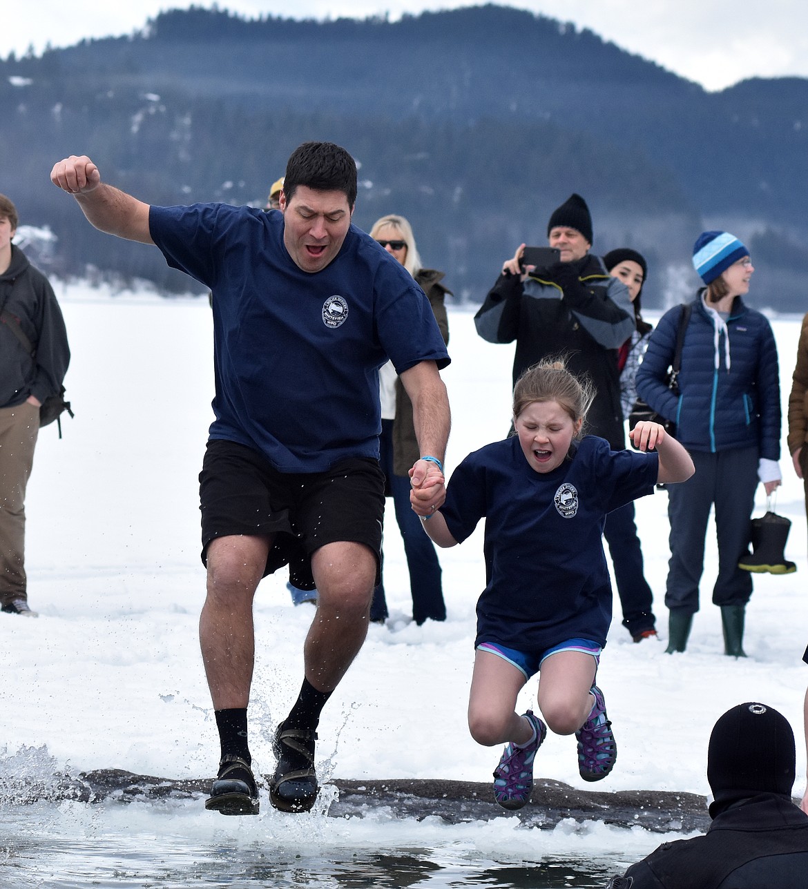 Participants jump into the icy waters of Whitefish Lake Saturday morning for the Whitefish Winter Carnival Penguin Plunge, which benefits Special Olympics Montana. (Heidi Desch/Whitefish Pilot)