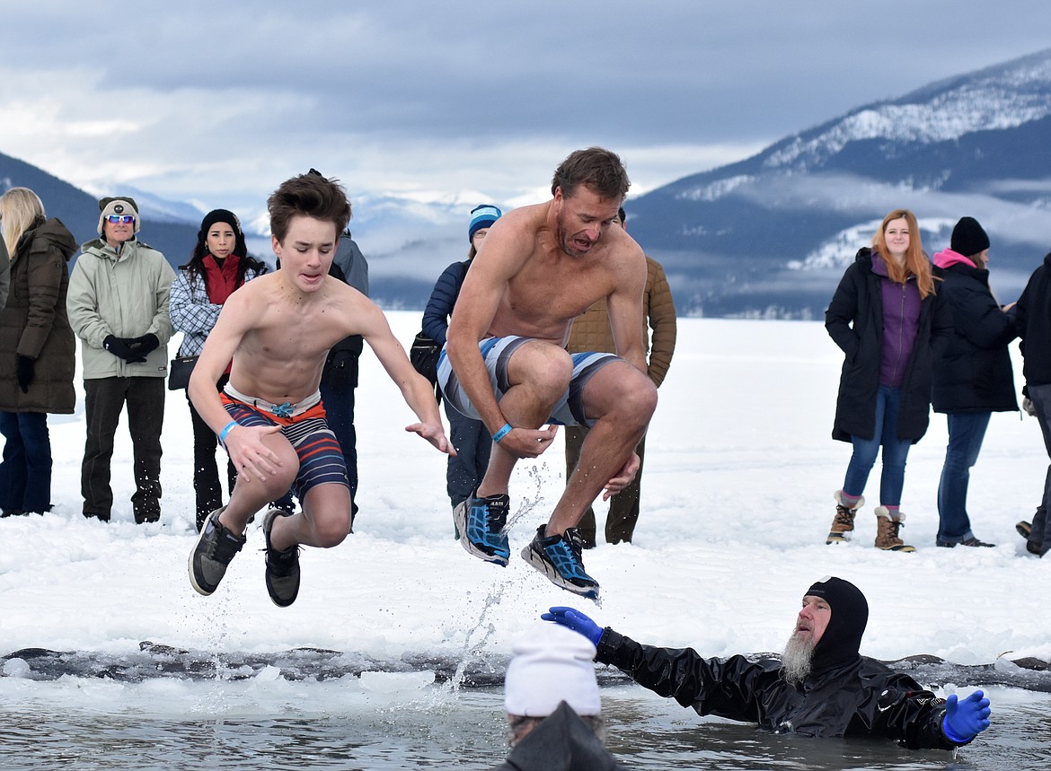 Participants jump into the icy waters of Whitefish Lake Saturday morning for the Whitefish Winter Carnival Penguin Plunge, which benefits Special Olympics Montana. (Heidi Desch/Whitefish Pilot)