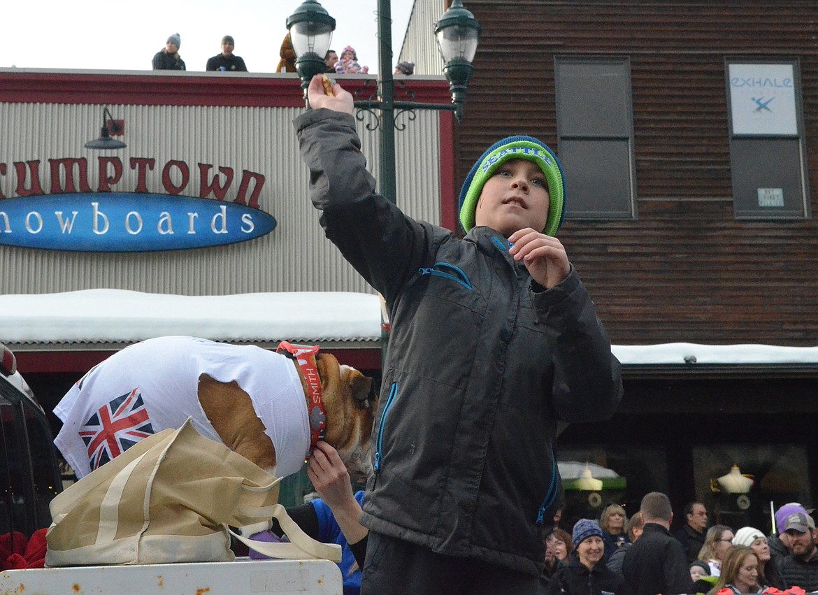 A youngster throws candy from The Springs at Whitefish float. (Heidi Desch/Whitefish Pilot)