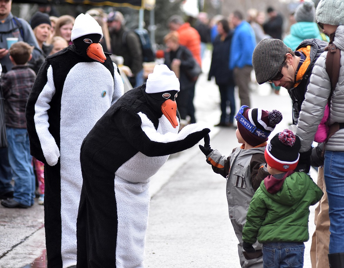 Penguins give high-fives before the start of the Whitefish Winter Carnival Grand Parade Saturday downtown. (Heidi Desch/Whitefish Pilot)