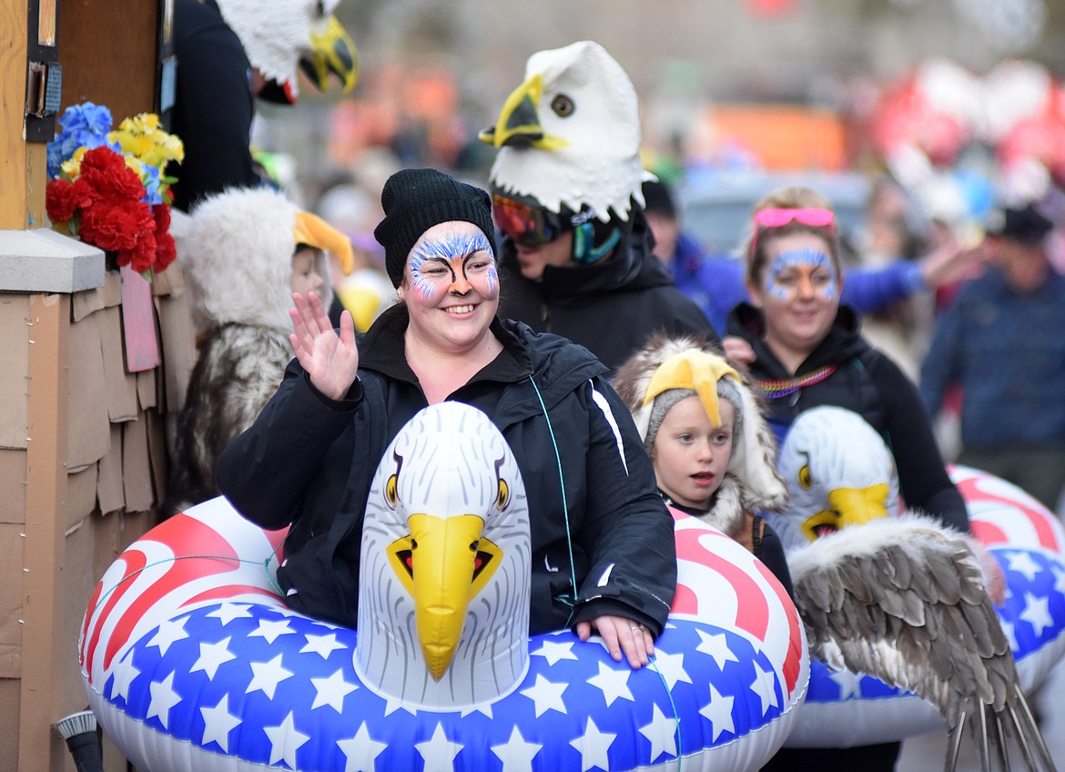 Folks walk along the North Valley Hospital float Saturday on Central Avenue. (Heidi Desch/Whitefish Pilot)