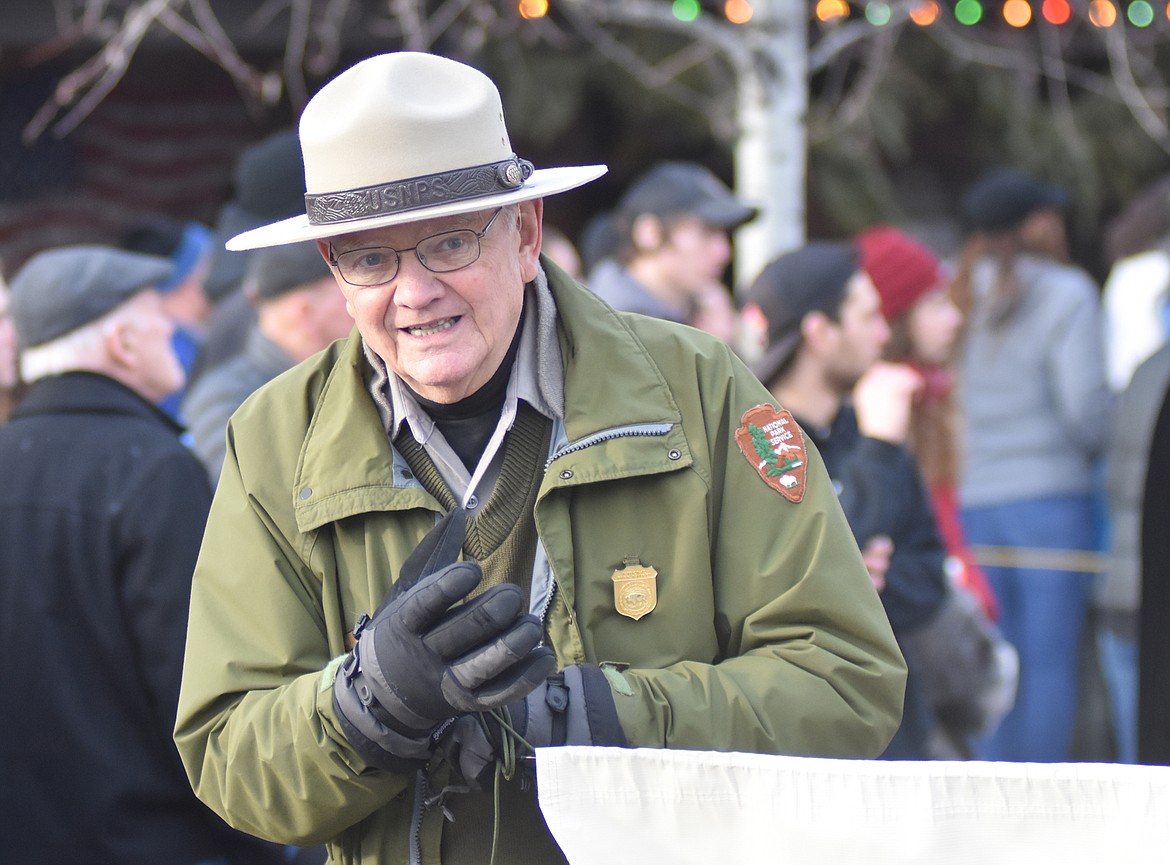 Glacier National Park Naturalist Bill Schustrom carries the Glacier Park banner down Central Avenue. (Heidi Desch/Whitefish Pilot)