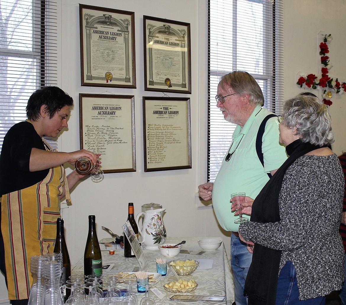 Volunteer server Brooke Barnett pours glasses of white wine during the library fundraiser, &#147;Armchair Traveler Passport.&#148; Participants were able to sample red and white wines provided by local wineries. (Kathleen Woodford/Mineral Independent)