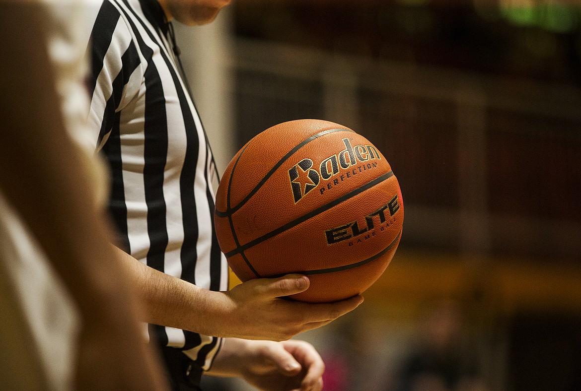 A referee holds the basketball during stoppage in play last Wednesday night at NIC.