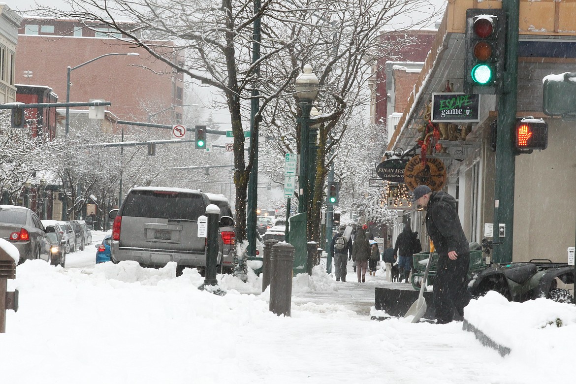 (DEVIN WEEKS/Hagadone News Network) 
Harlan Harmon, a landscaper for The Coeur d&#146;Alene Resort, shovels the sidewalk at First Street and Sherman Avenue following a dump of snow Saturday morning. Despite the snow, rain and wind, downtown was still fairly busy with locals and visitors shopping, dining out or walking their dogs.