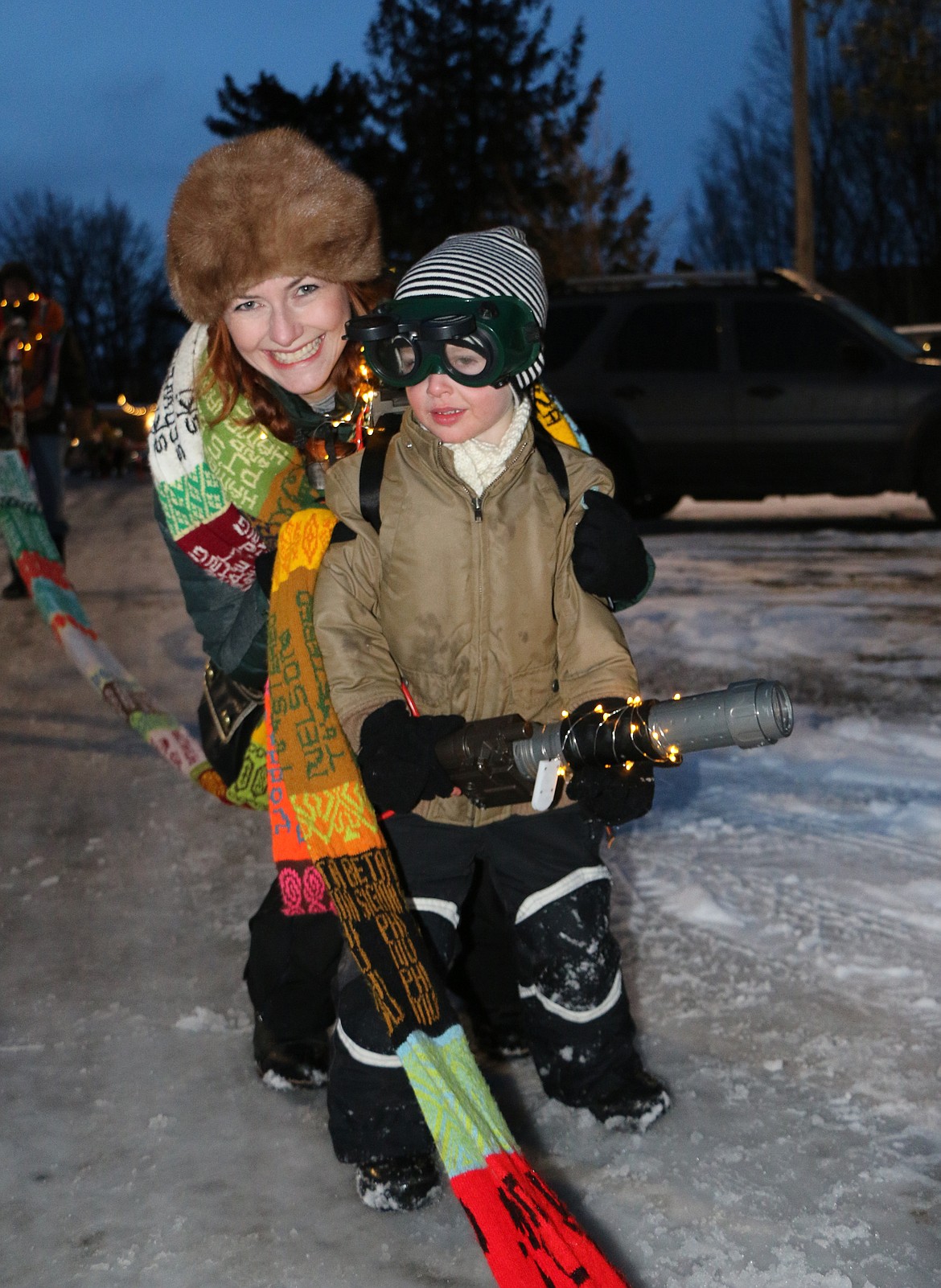 (Photo by CAROLINE LOBSINGER)
A pair get dressed up in lights &#151; and a 700-foot scarf &#151; as they wait for the start of the Winter Carnival parade in downtown Sandpoint on Friday.