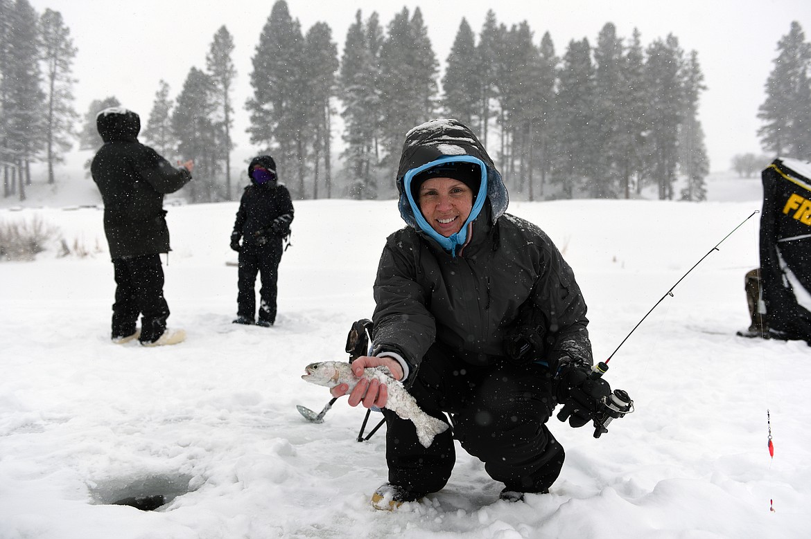 Sheli Babb, of Kalispell, holds a rainbow trout caught during the Becoming an Outdoors-Woman ice fishing workshop at Pine Grove Pond on Saturday. (Casey Kreider/Daily Inter Lake)