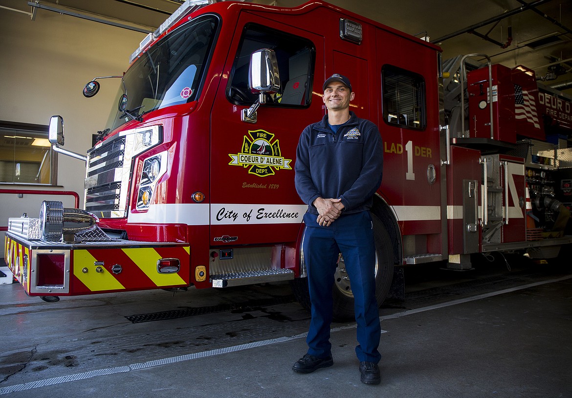 Coeur d'Alene firefighter Justin Wearne poses for a portrait next to a CDA's Ladder 1 firetruck on Thursday. Wearne helped save George Iredale's life on a flight from Oakland to Mexico a few weeks ago. (LOREN BENOIT/Press)