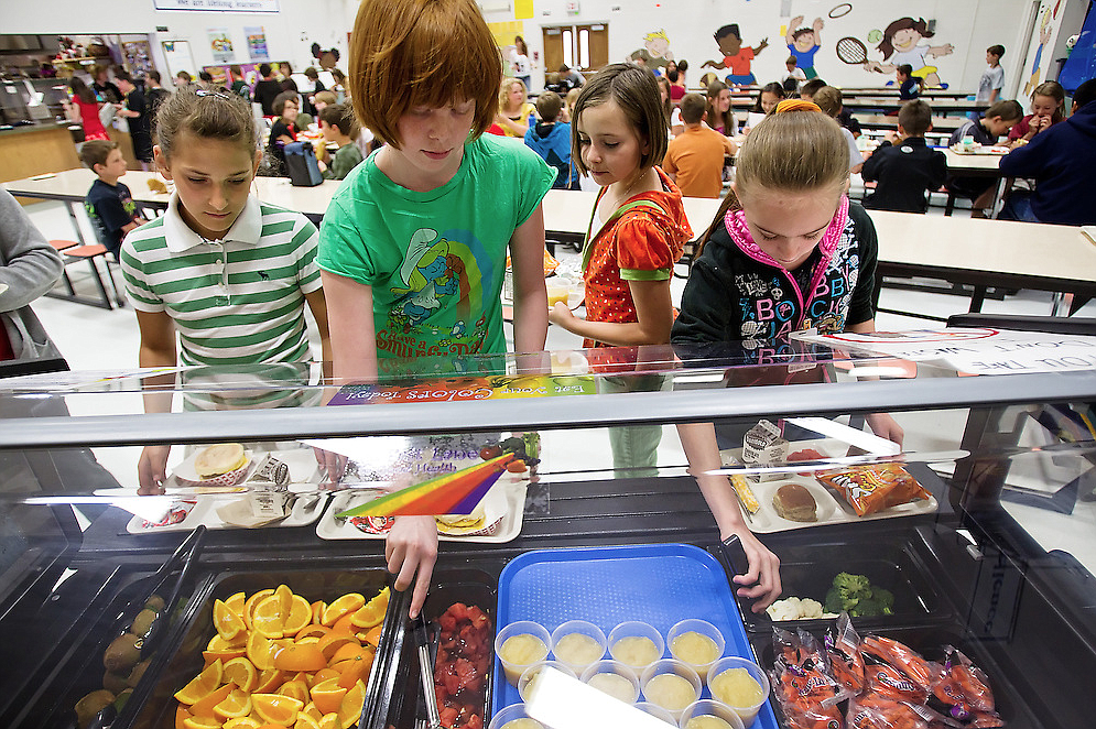 Bryan Elementary School fifth graders line up to scoop their favorite fruits and vegetables during lunchtime in this 2010 photo. The Coeur d'Alene School District and Community Action Partnership Coeur d'Alene Food Bank are two partners in the Strengthening Families North Idaho website, www.strengtheningfamiliesni.com., a new site that launched Monday to connect families with resources including nutrition, education, housing assistance and more. From left, Tori Taylor, Sierra Magee, Rikki Hickman and Shelly Lingwell. (SHAWN GUST/Press file)