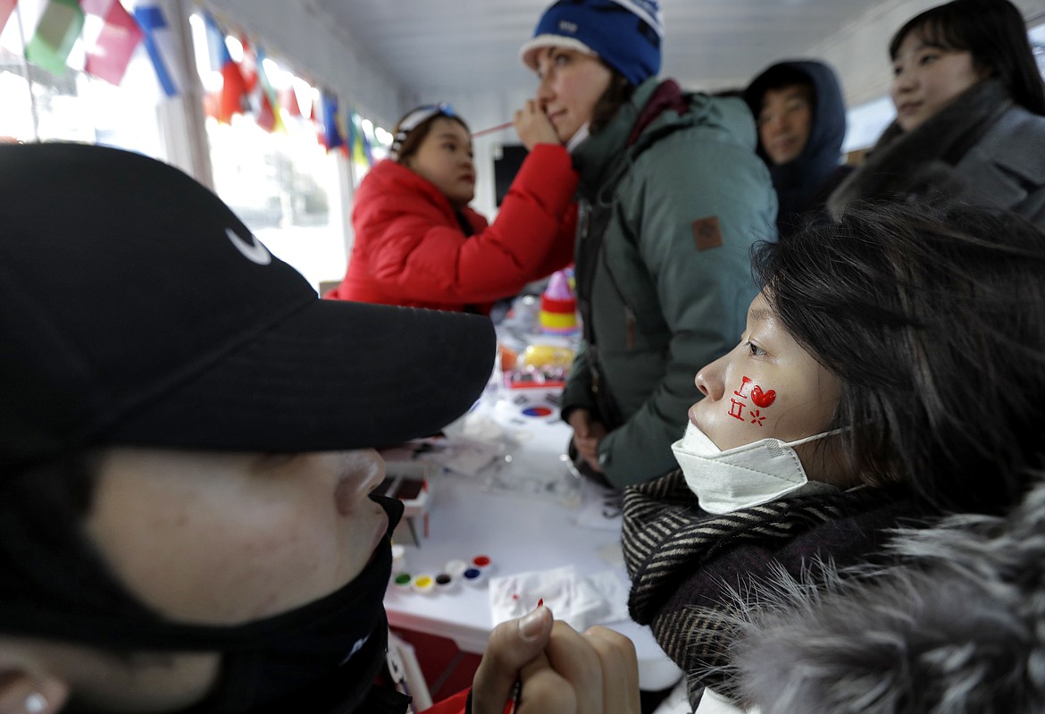 Fans have their faces painted prior to the women&#146;s slopestyle qualifying at Phoenix Snow Park at the 2018 Winter Olympics in Pyeongchang, South Korea, Saturday, Feb. 17, 2018. (AP Photo/Gregory Bull)