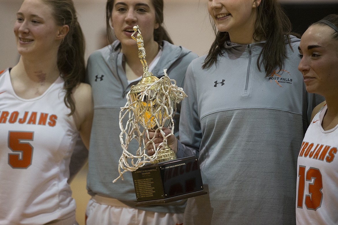 Sydney Parks of Post Falls holds the 5A Region 1 championship trophy last Tuesday.