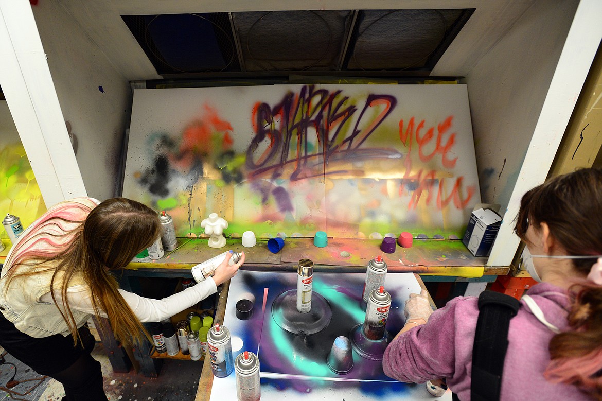 From left, Kiara Collier, a senior, and Alanna Glennon, a junior, use spray paint as they work on independent projects in teacher Kristie Caratelli&#146;s International Baccalaureate art class.