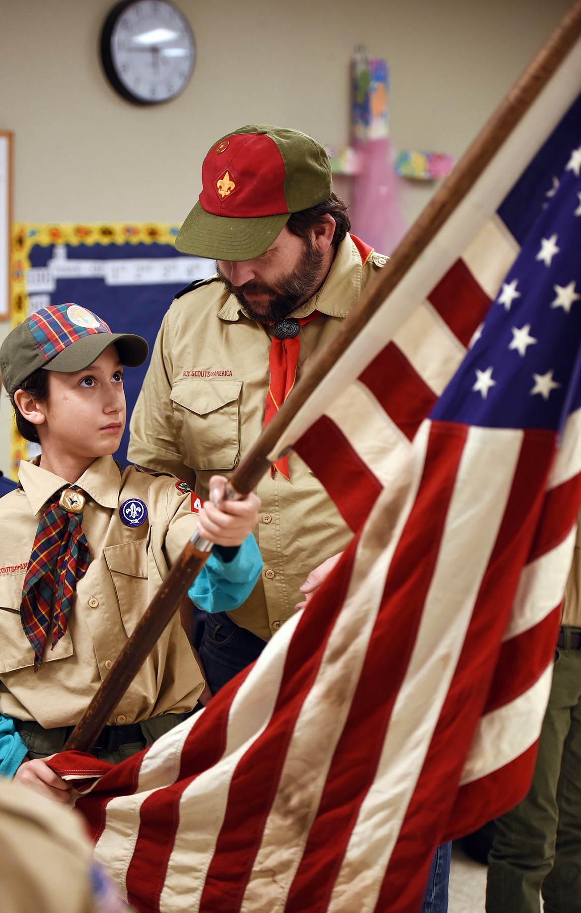 Cub Master John Sonderegger instructs Noah Martinez, 10, a Webelo 2, on what to do during the flag ceremony at the beginning of their meeting on Tuesday evening, January 16, at St. Matthew's School in Kalispell. Pack 4944 is the oldest pack in the Flathead Valley and one of the oldest in Montana.(Brenda Ahearn/Daily Inter Lake)