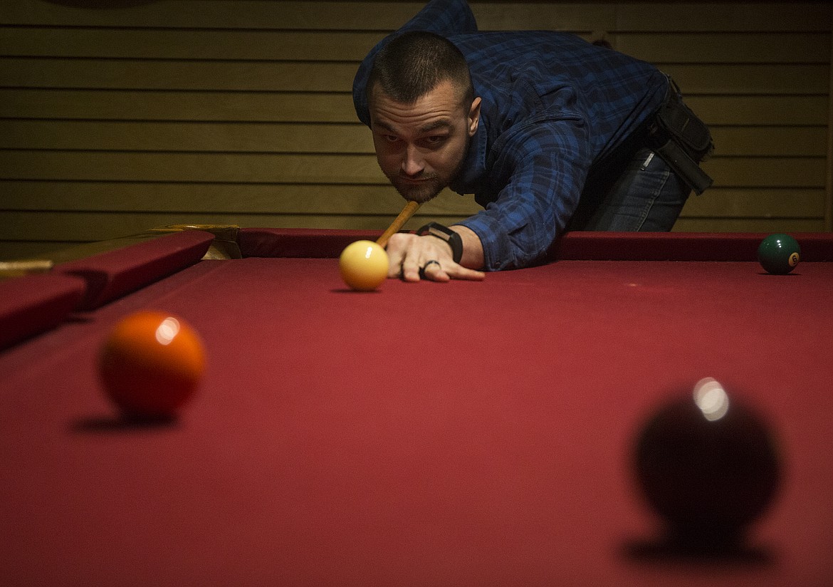 Shane Kelly plays a game of pool in the Silver Lake Mall at  Bulldog Pipe &amp; Cigar Shop.