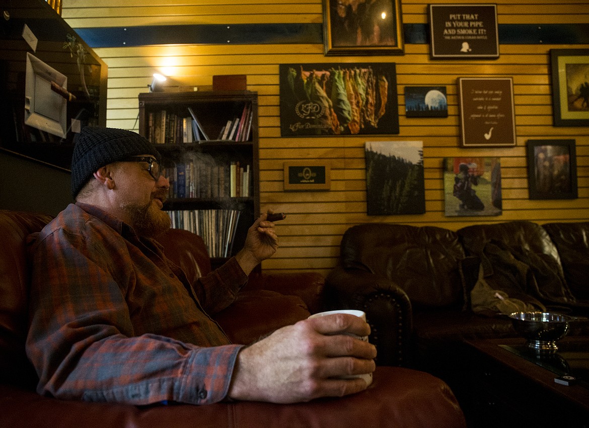 Clay Howard relaxes in a lounge chair as he enjoys a cigar at Bulldog Pipe and Cigar.