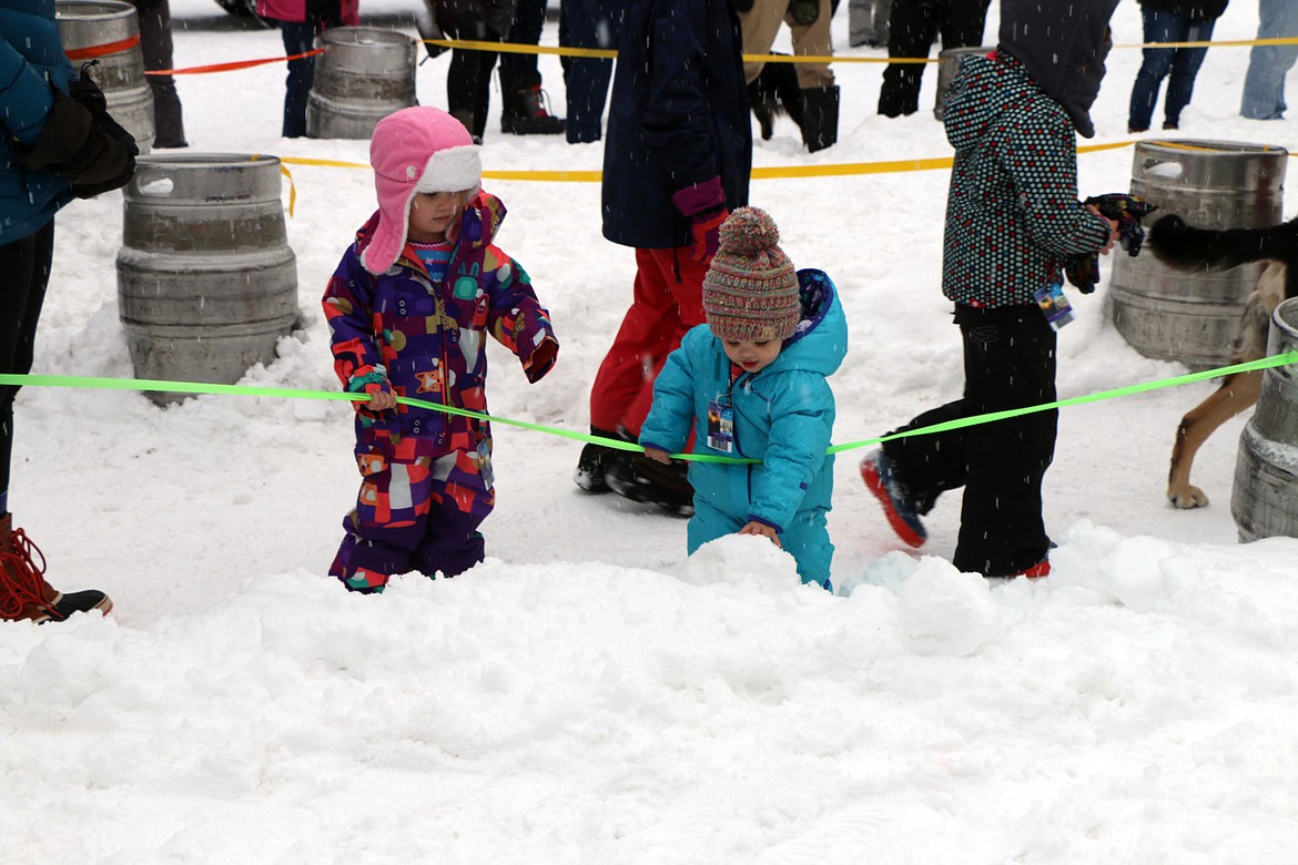 (Photo by CAROLINE LOBSINGER)A pair of K9 Keg Pull fans play in the snow between heats.