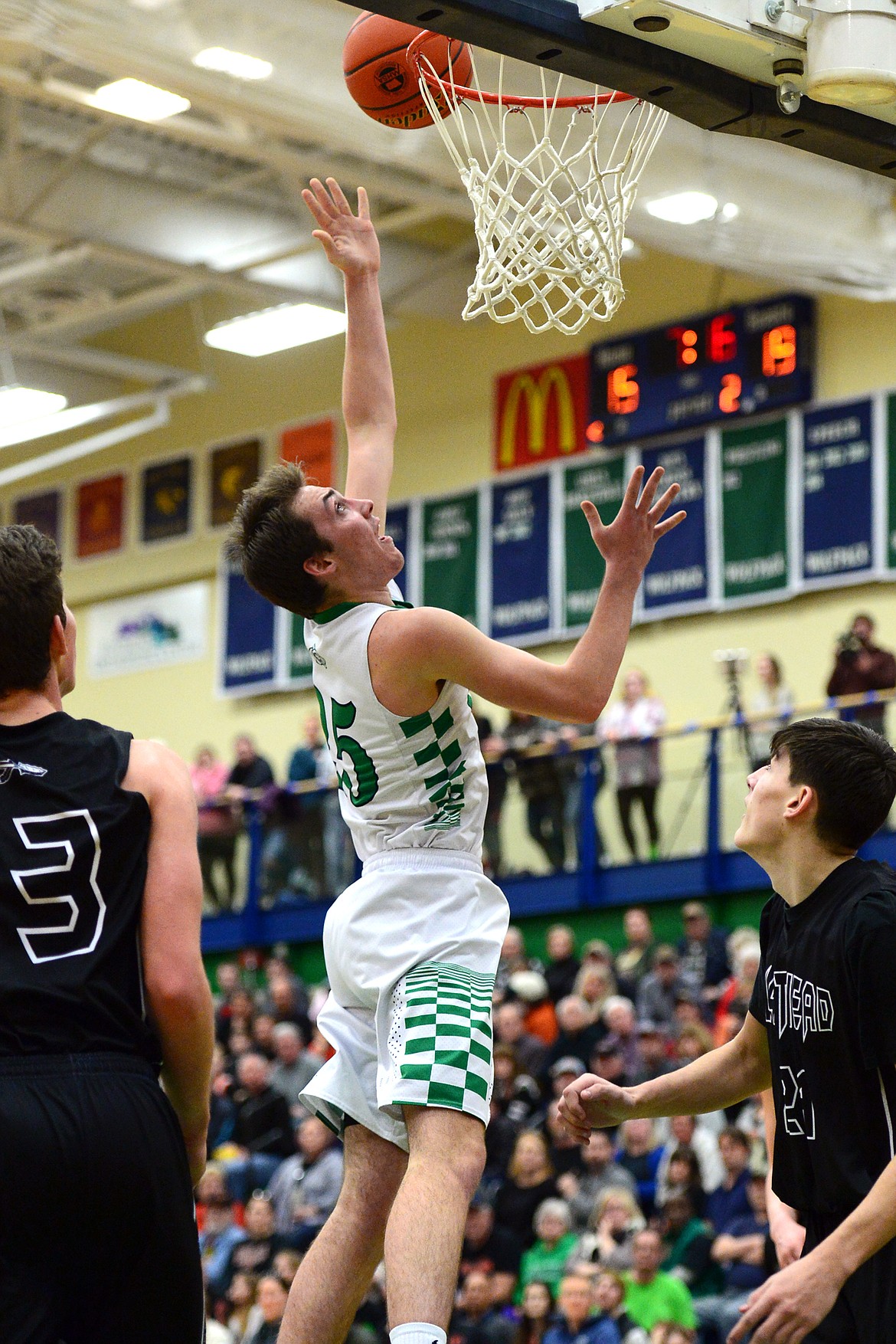 Glacier&#146;s Nick Whitman drops in two points between Flathead defenders Sam Elliott (33) and Oz Allen (24) during a 59-56 crosstown victory for the Braves Thursday night at Glacier High School. (Casey Kreider/Daily Inter Lake)