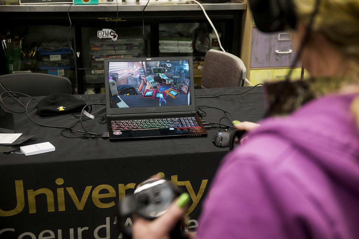 Mary Marienau interacts with a robot while playing a virtual reality game Friday afternoon at Gizmo's classroom inside the Hedlund Building at North Idaho College. (LOREN BENOIT/Press)