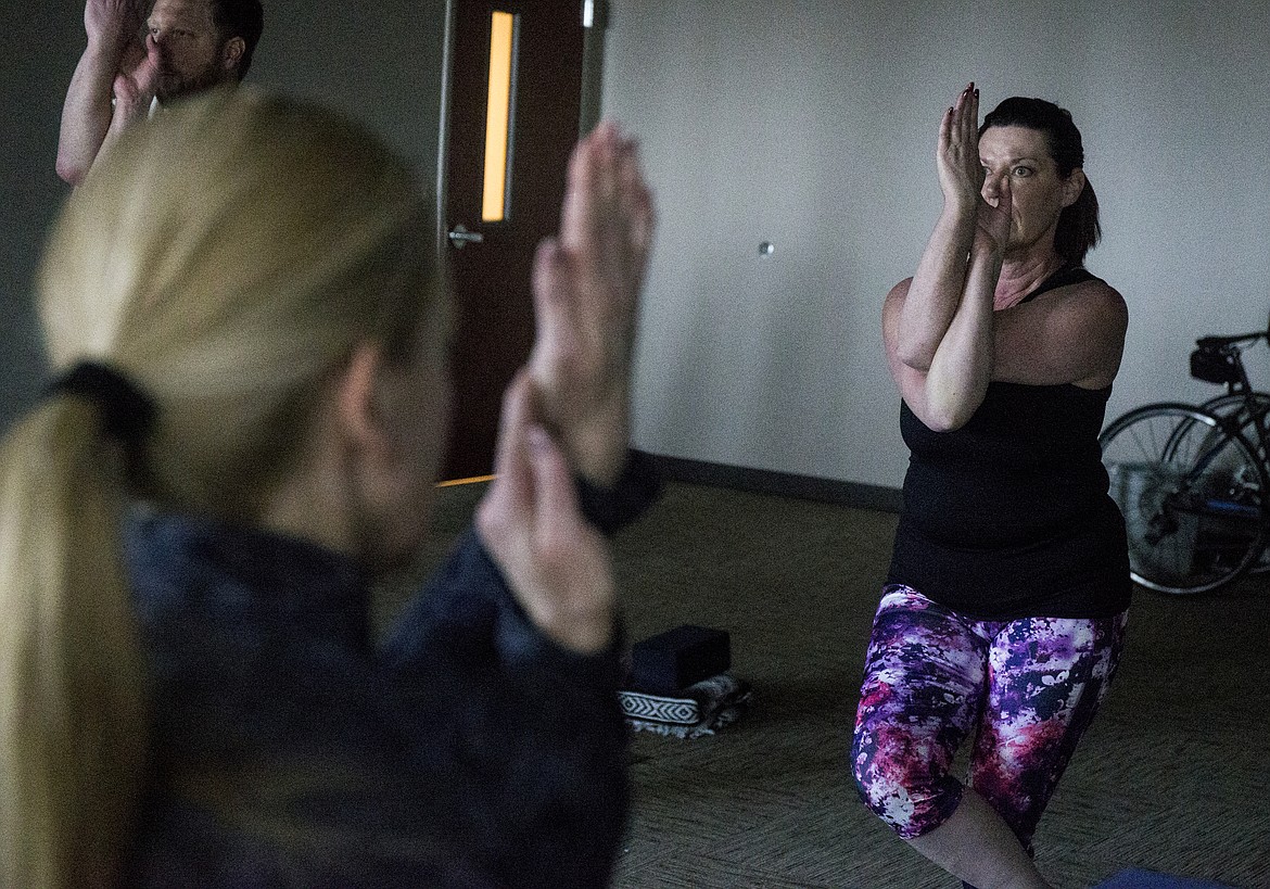 Teresa Benner does an eagles twist pose during a yoga class Wednesday afternoon at Post Falls City Hall. (LOREN BENOIT/Press)