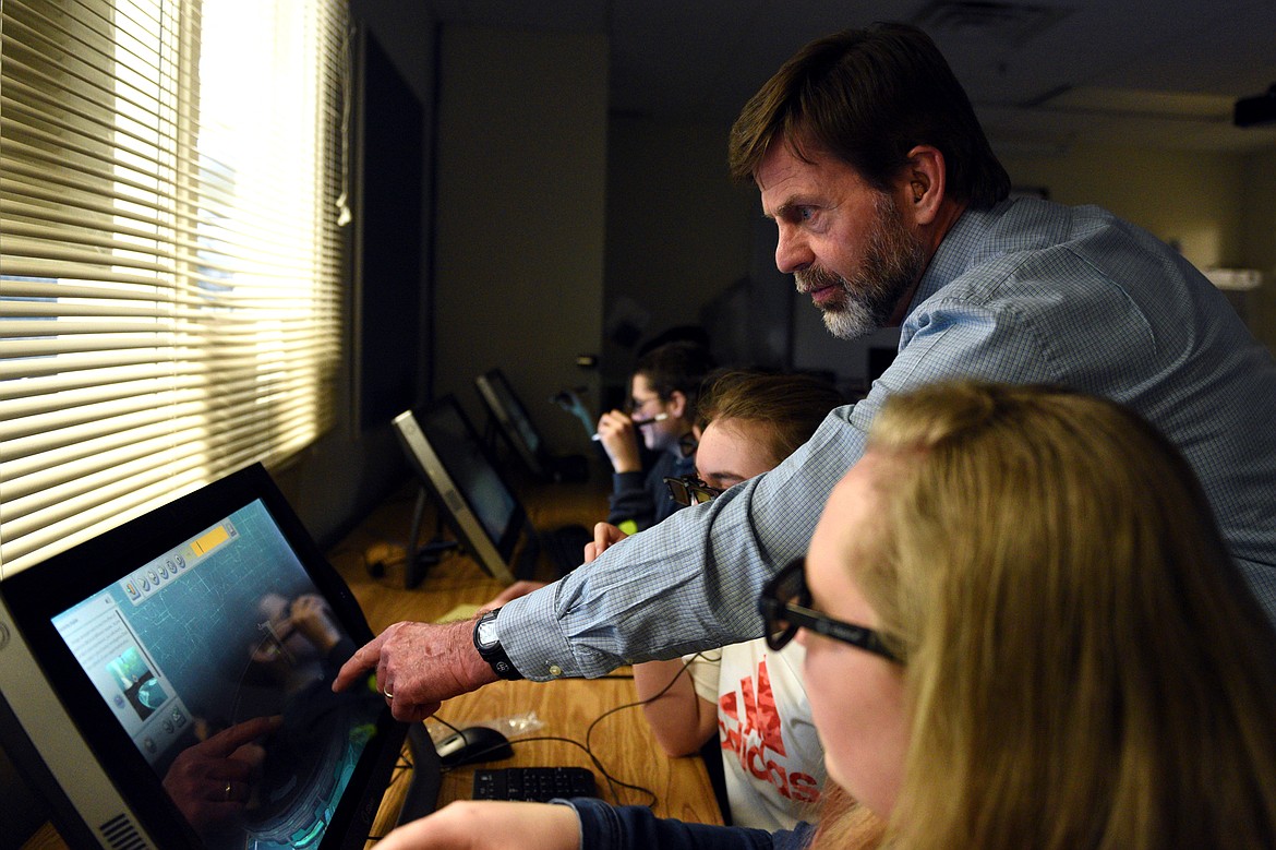 Teacher Tom Berquist works with eighth-graders in the zSpace learning lab at Columbia Falls Junior High on Thursday. zSpace uses augmented and virtual reality technology to create an interactive experience using a desktop computer. (Casey Kreider/Daily Inter Lake)