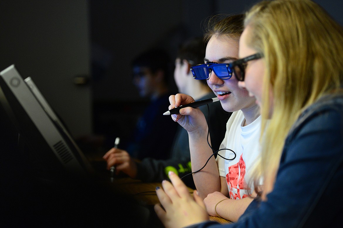 Eighth-graders Abby DeGolier, left, and Hailie Holm work in the zSpace learning lab during teacher Tom Berquist's science class at Columbia Falls Junior High on Thursday. zSpace uses augmented and virtual reality technology to create an interactive experience using a desktop computer. (Casey Kreider/Daily Inter Lake)