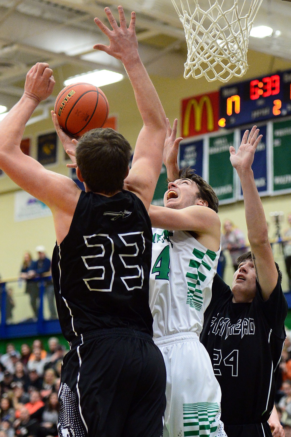 Glacier&#146;s Alex Whitman looks to shoot between Flathead defenders Sam Elliott (33) and Oz Allen (24) during a 59-56 crosstown victory for the Braves Thursday night at Glacier High School. (Casey Kreider/Daily Inter Lake)