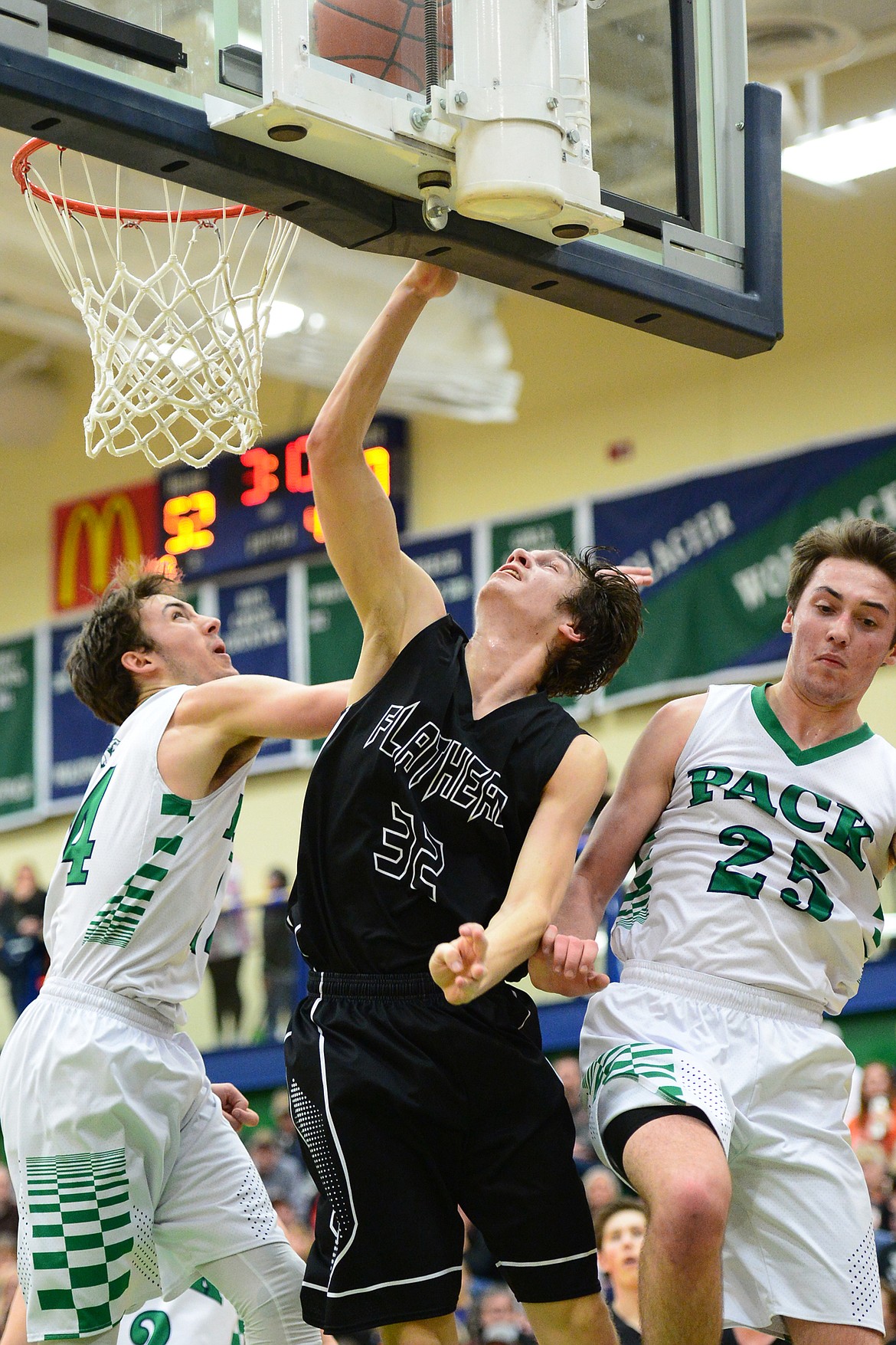 Flathead&#146;s Tyler Johnson banks in two points against Glacier defenders  Alex Whitman (24) and Nick Whitman (25) during a 59-56 crosstown victory for the Braves Thursday night at Glacier High School. (Casey Kreider/Daily Inter Lake)