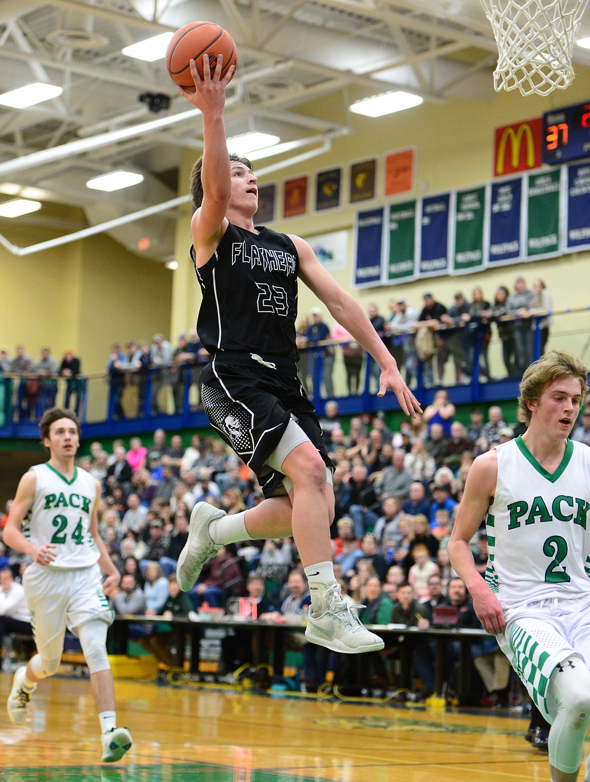 Flathead&#146;s Eric Seaman lays in two points between Glacier&#146;s Alex Whitman (24) and Caden Harkins (2) during a 59-56 crosstown victory for the Braves Thursday night at Glacier High School. (Casey Kreider/Daily Inter Lake)