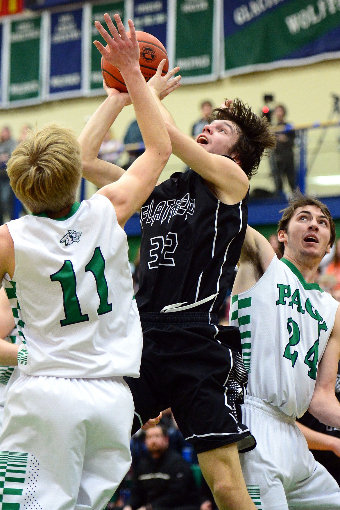 Flathead&#146;s Tyler Johnson drives to the hoop between Glacier defenders Brec Rademacher (11) and Alex Whitman (24) during a 59-56 crosstown victory for the Braves Thursday night at Glacier High School. (Casey Kreider/Daily Inter Lake)