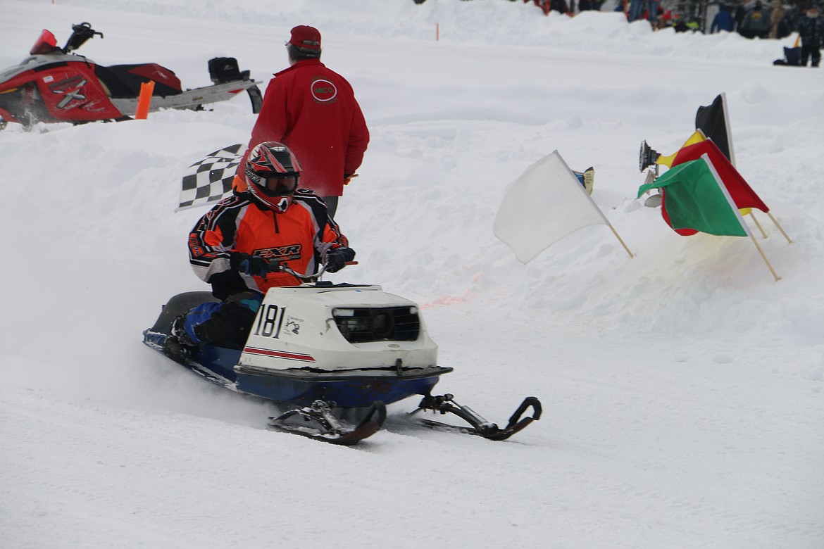 (Photo by MARY MALONE)
A racer crosses the finish line during the Priest Lake Vintage Snowmobile Races on Sunday.