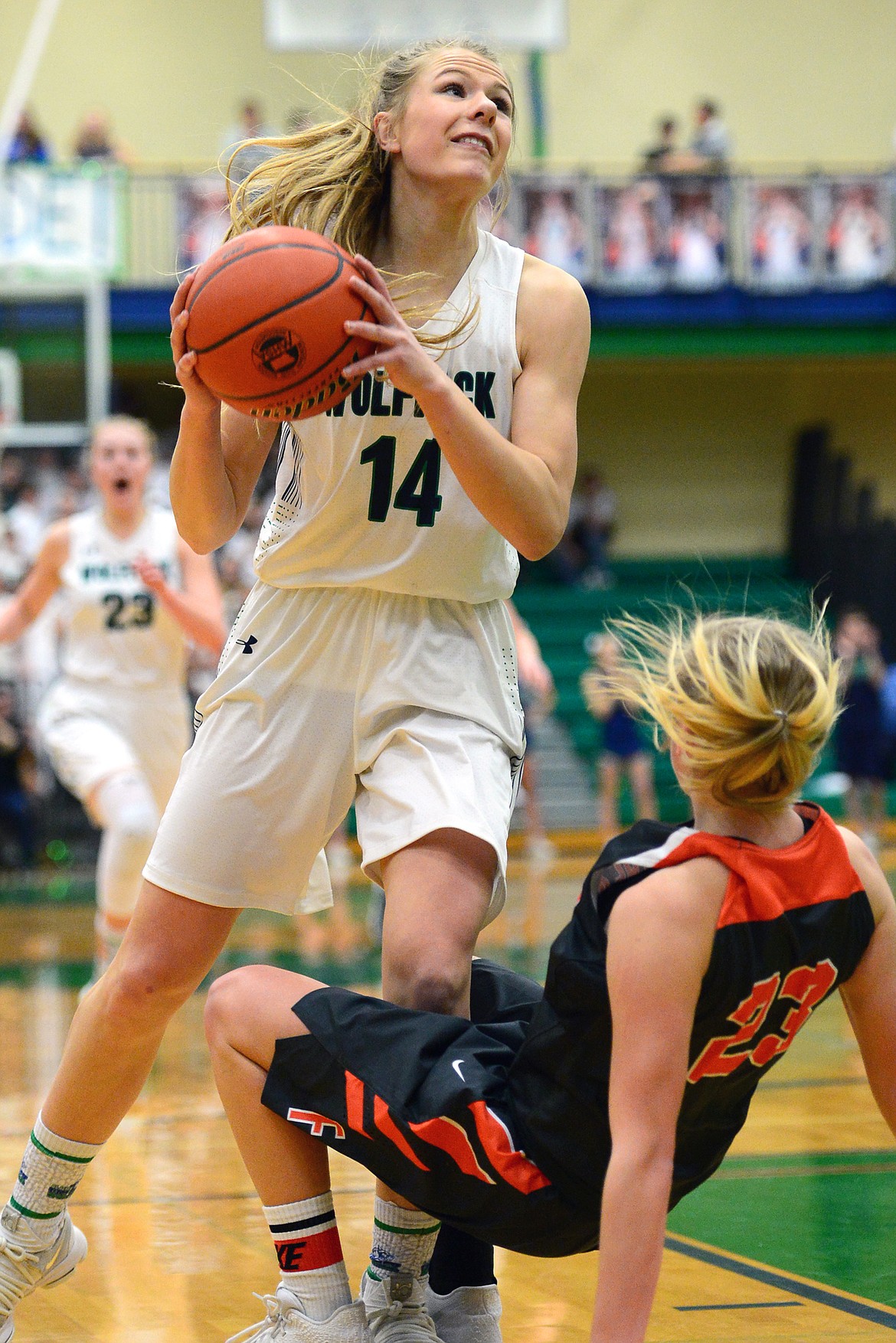 Glacier&#146;s Aubrie Rademacher drives to the hoop with Flathead&#146;s Clara Vandenbosch attempting to draw a charge on the play. The Lady Wolfpack went on to claim a 30-24 crosstown victory Thursday night at Glacier High School. (Casey Kreider/Daily Inter Lake)