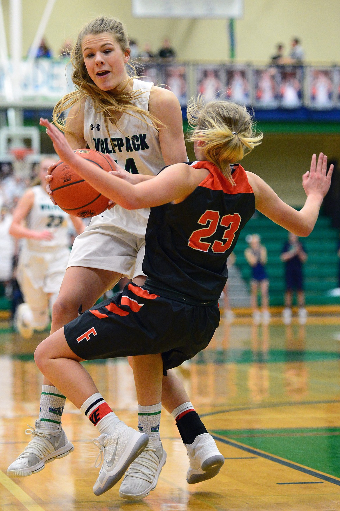 Glacier&#146;s Aubrie Rademacher drives to the hoop with Flathead&#146;s Clara Vandenbosch attempting to draw a charge on the play. The Lady Wolfpack went on to claim a 30-24 crosstown victory Thursday night at Glacier High School. (Casey Kreider/Daily Inter Lake)