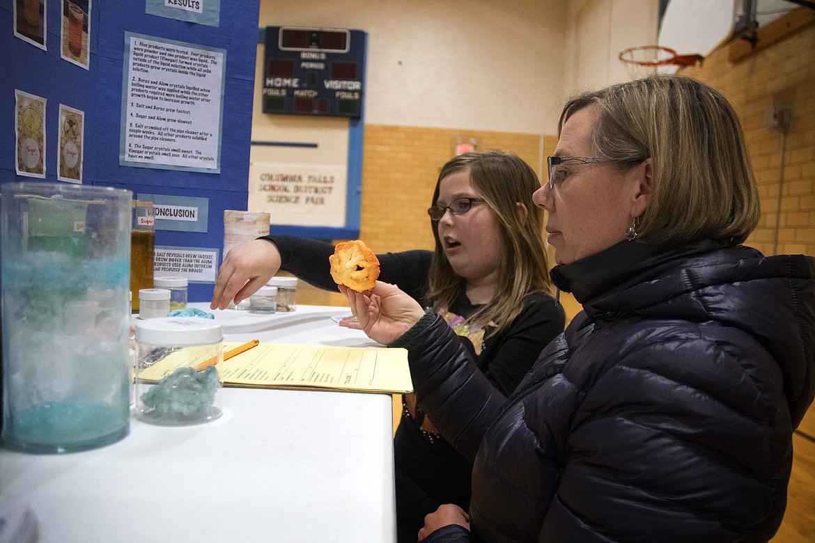 Judge Jen Golan speaks with third grader Synthea Freiheit about her display on rock crystals at the Columbia Falls School District Science Fair at Glacier Elementary Tuesday. (Jeremy Weber photo)