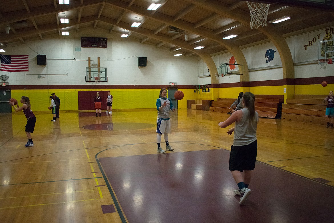 With Troy seniors Allie Coldwell and Kaitlyn Downey in the foreground, the Lady Trojans practice free throws Wednesday, Feb. 21. (Ben Kibbey/The Western News)