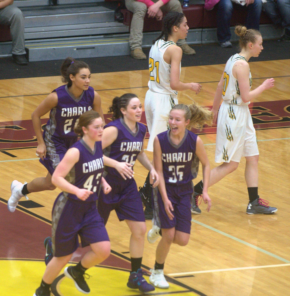 CHARLO HIGH School girl’s basketball team celebrates after their first period surge against St. Regis. (From left, bottom row): Allie Delaney (43), Sakoya Gaustad (25) , Carlee Fryberger (35) and Tyrah Hammond (22) celebrate after a 12-0 run against the Lady Tigers in the Western Class 14-C District Championship Saturday night at Joe McDonald Gym at Salish Kootenai College. (Jason Blasco/Lake County Leader)