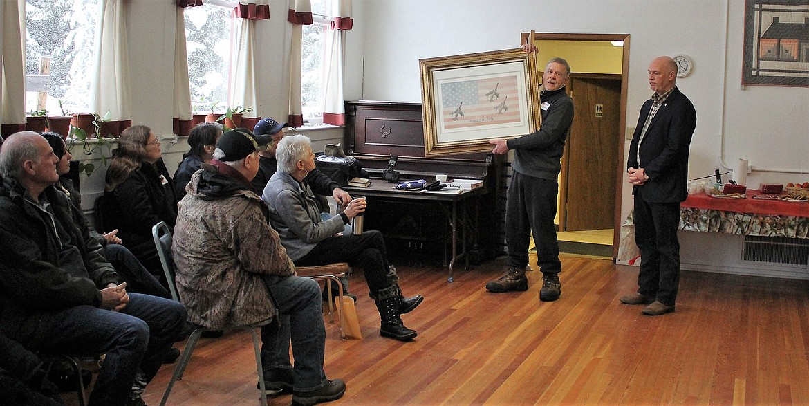 Bruce Charles holds a painting, &#147;Forget me not&#148;, to represent veterans who have fallen in the line of duty. &#147;I simply represent many other people such as myself some of whom have done far more than me,&#148; he said after accepting an award for his military service from House Rep. Greg Gianforte on Feb. 17. (Kathleen Woodford/Mineral Independent).