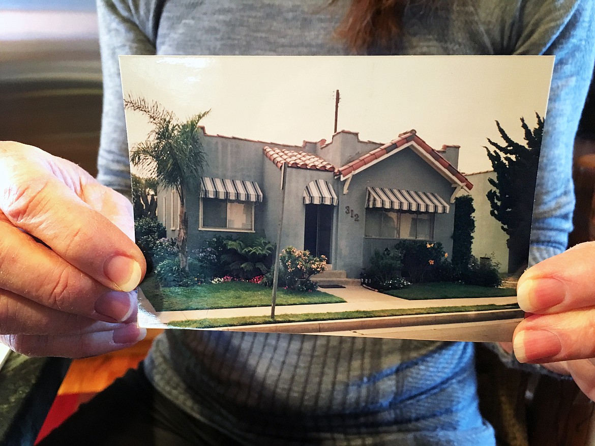 Linda Babiak shows a before picture of her home on 312 Eliot Lane in Long Beach, California.