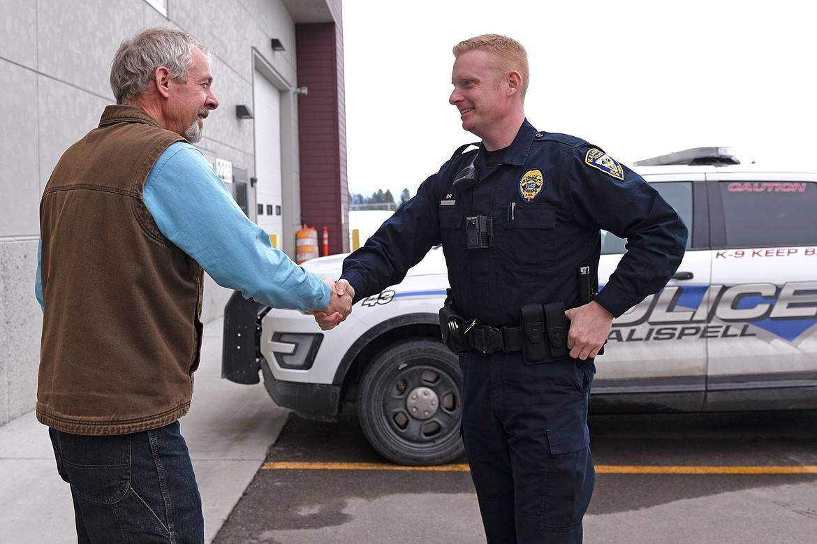 Kalispell Police Department officer Jason Parce, right, and Eric Brown shake hands after meeting for the first time on Friday, March 2. Brown suffered a heart attack outside his job at Flathead Valley Community College last May and Parce responded to the scene to start resusication on Brown. (Casey Kreider/Daily Inter Lake)