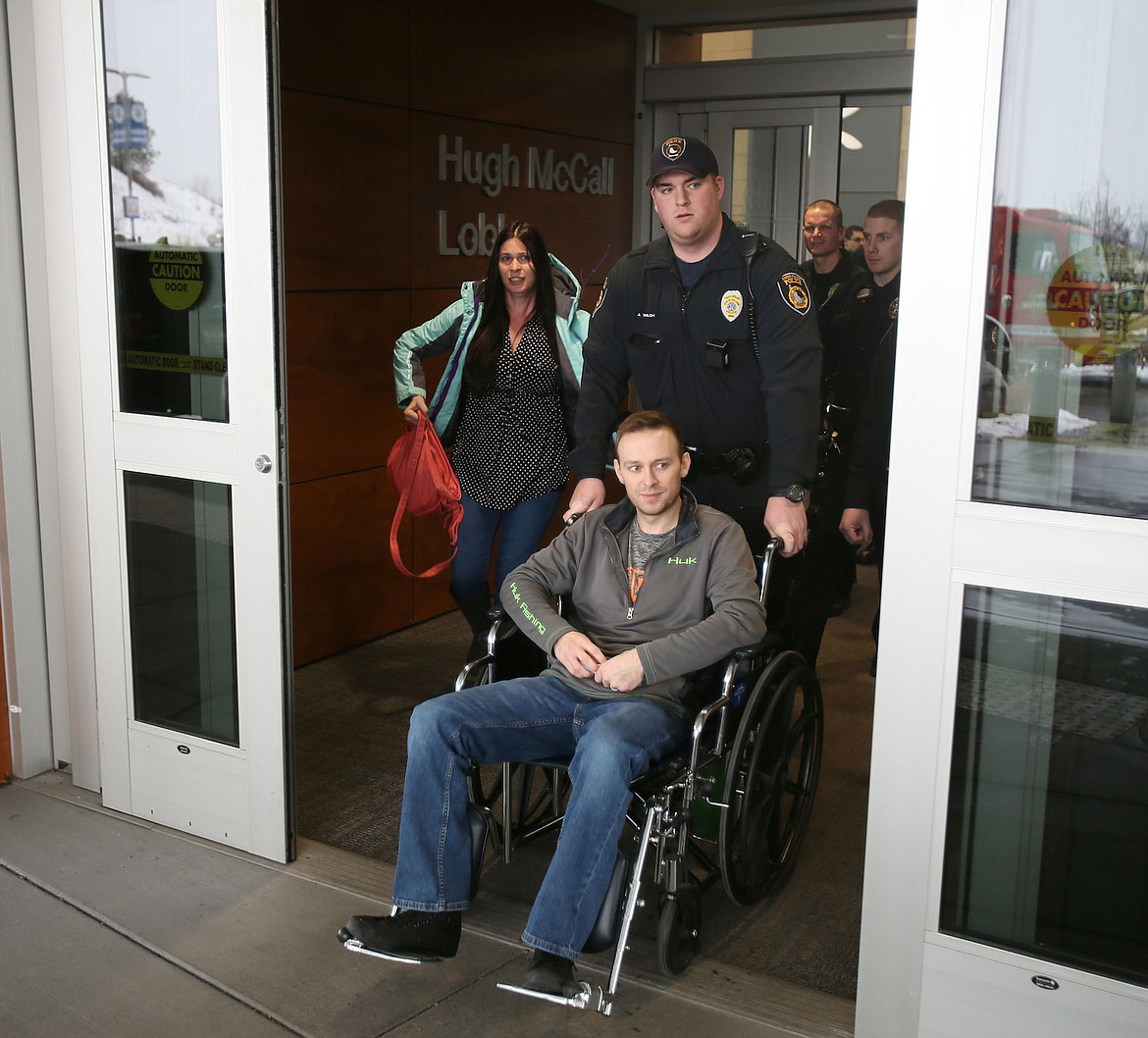 Coeur d&#146;Alene Police patrol officer Charles Hatley is escorted out of Kootenai Health Friday by colleagues and his wife after recovering from a gunshot incurred in the line of duty Tuesday night. (Judd Wilson/PRESS)
