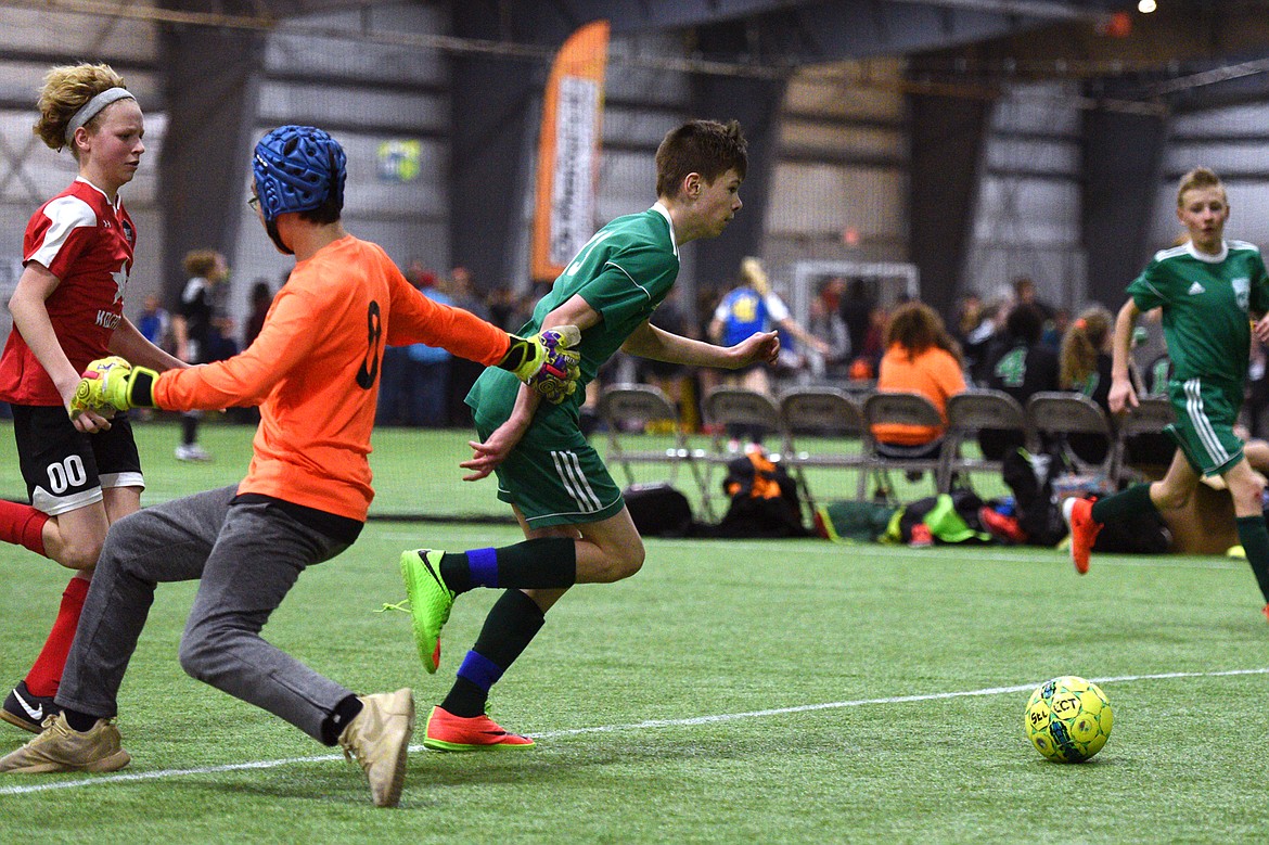 Flathead Force 03's Sol Dalla Betta slips past the Sandpoint Striker keeper for a goal during the Montana Indoor Soccer Championships at the Flathead County Fairgrounds on Saturday. (Casey Kreider/Daily Inter Lake)