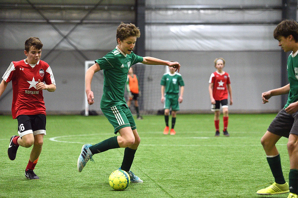 Flathead Force 03's Sullivan Coggins dribbles upfield against the Sandpoint Strikers during the Montana Indoor Soccer Championships at the Flathead County Fairgrounds on Saturday. (Casey Kreider/Daily Inter Lake)