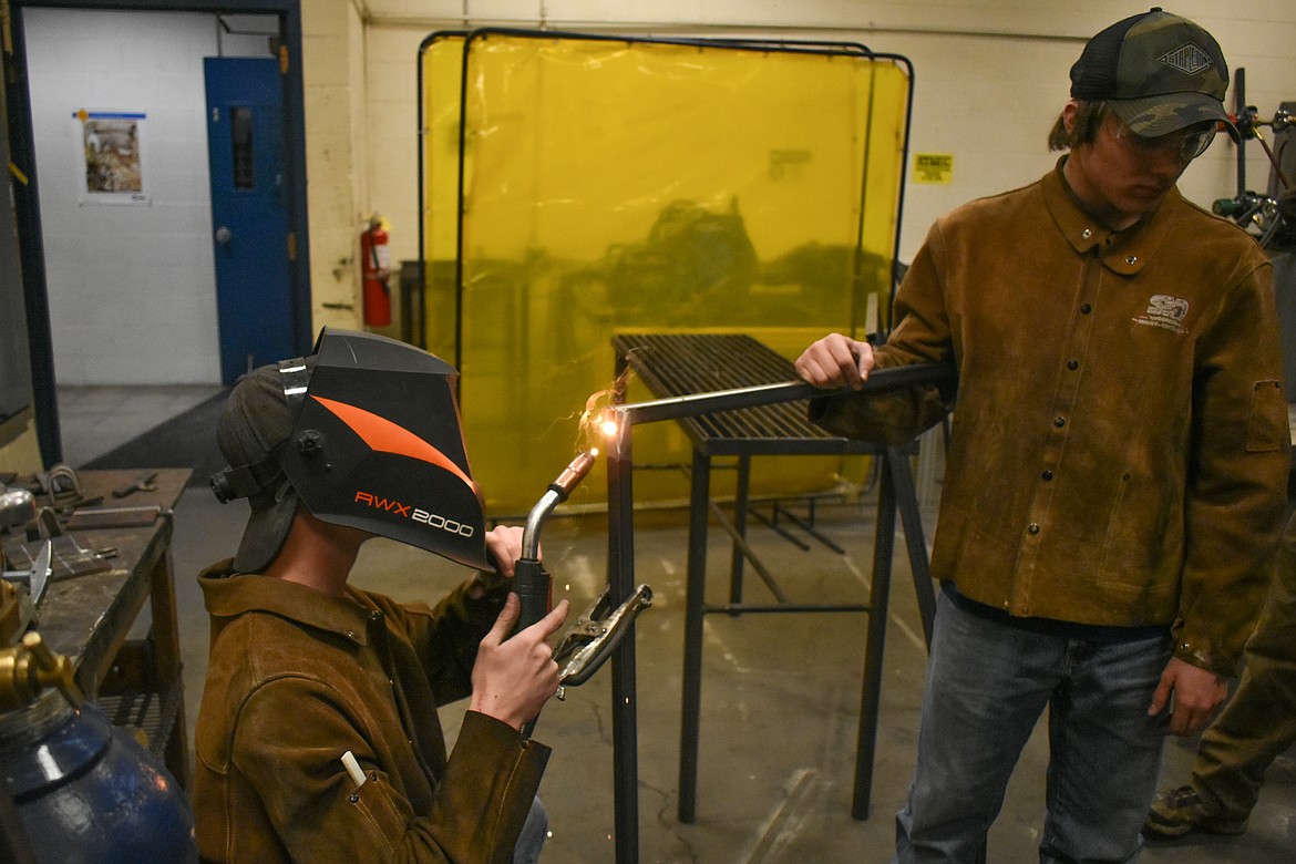 Troy sophomores Brodie Gravier and Ricki Fisher weld a door frame for the booth in the background that Troy High School students are fabricated as a class project, March 6. (Ben Kibbey/The Western News)