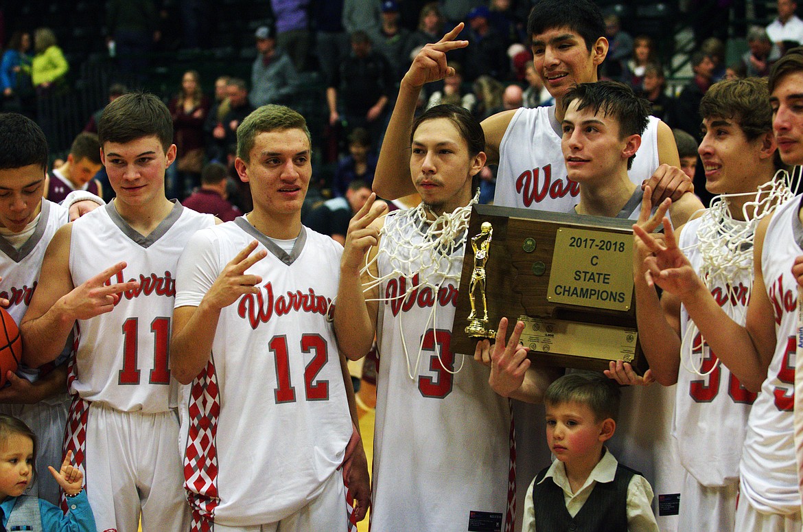 ARLEE WARRIORS (from left): Darshan Bolin (24), Chase Gardner (11), Greg Whitesell (12), Will Mesteth (3), Isaac Fisher (33), Phillip Malatare (4), Lane Schall (30), and Lane Johnson (5) celebrate capturing the MHSA Class C State championship Saturday night at Butte Civic Center. (Jason Blasco/Lake County Leader)