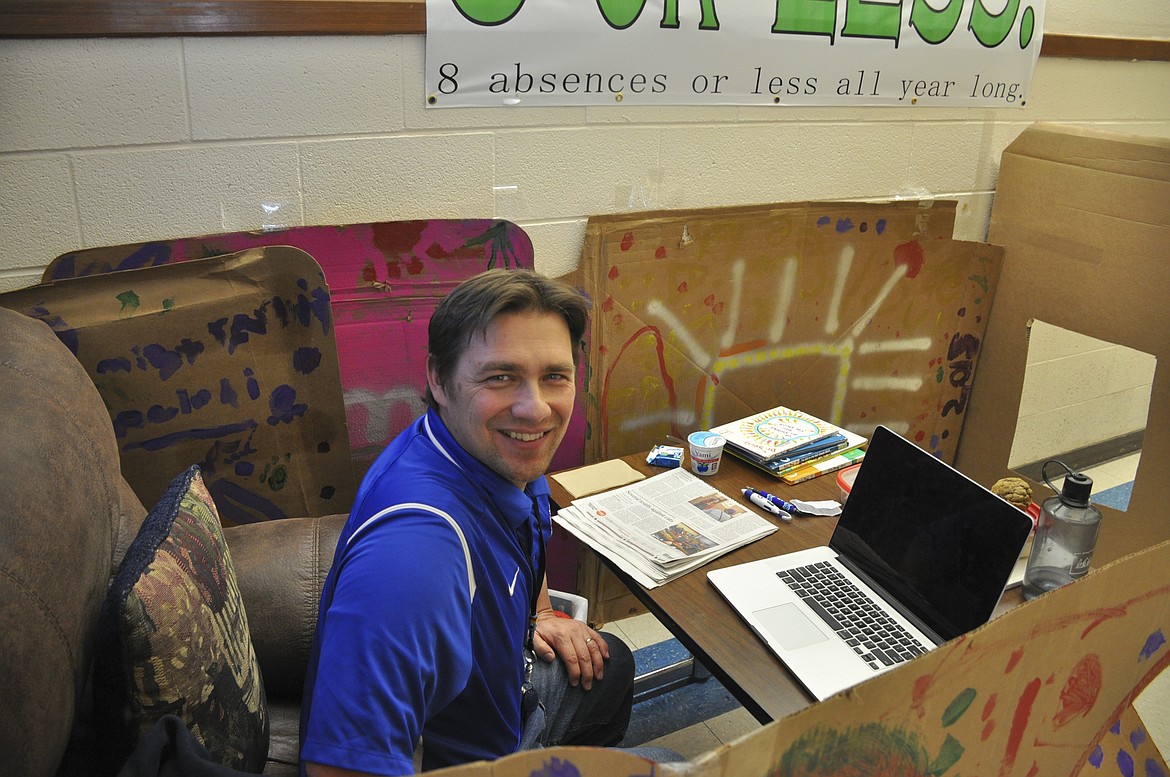 ST. IGNATIUS Elementary Principal Tyler Arlint takes a break from administrative work and greeting students as he spends the day in a student-decorated box on March 1. (Ashley Fox/Lake County Leader)